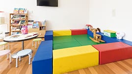 カラフルなクッションで囲まれたキッズスペース。遊具も備えられている。